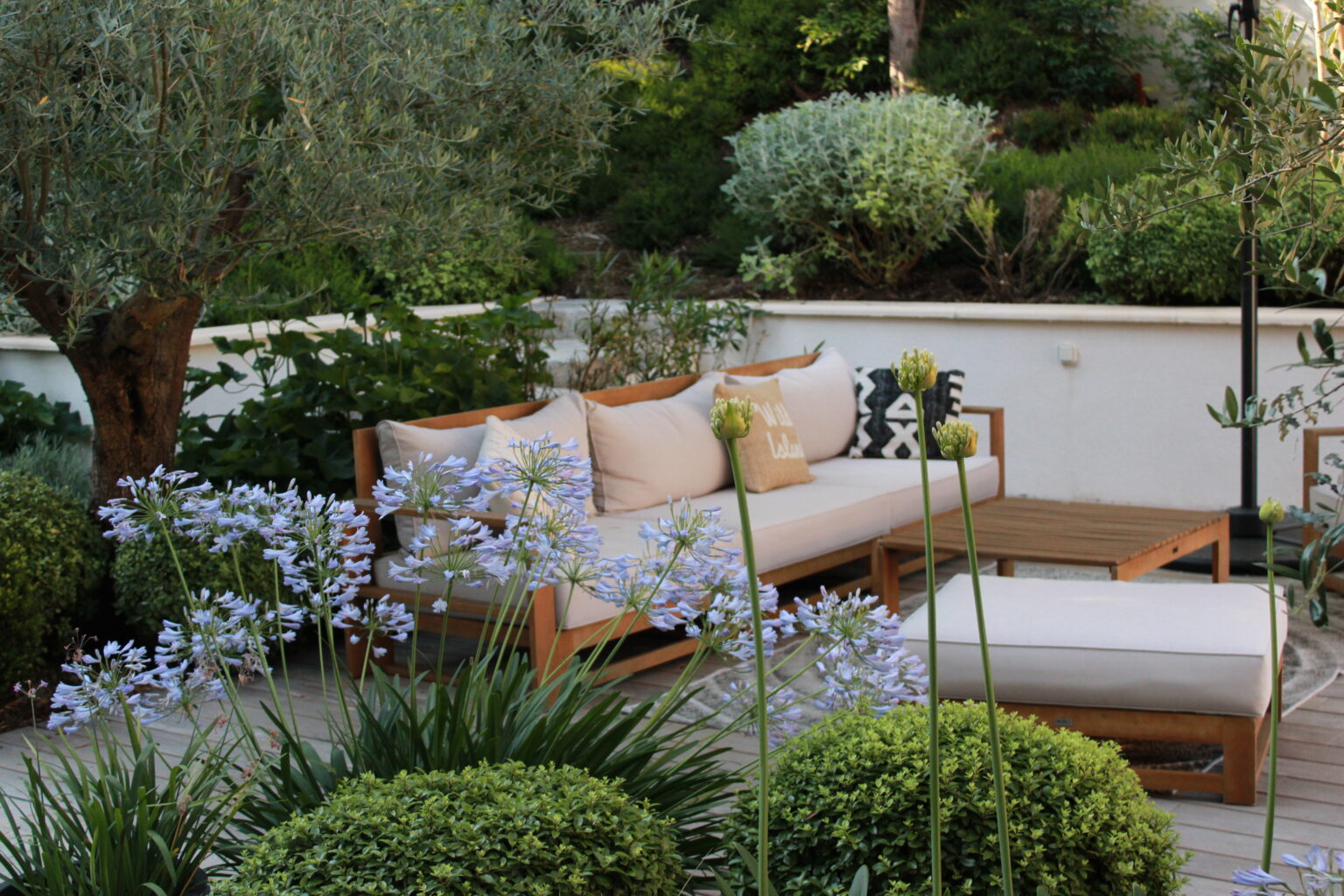 Terrasse entourée de massifs fleuris
